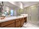 Bathroom features a vanity with wood cabinets, white countertops, and a shower with glass doors at 6728 Regency Ridge Ct, Las Vegas, NV 89148
