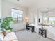 Bright living room featuring large windows, a cozy couch, and a functional desk area at 6728 Regency Ridge Ct, Las Vegas, NV 89148