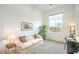 Comfortable living room with a cream sofa, large window, and a dedicated desk space at 6728 Regency Ridge Ct, Las Vegas, NV 89148