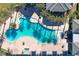 Aerial shot of a luxurious community pool with palm trees, lounge chairs, and shaded cabanas at 6728 Regency Ridge Ct, Las Vegas, NV 89148