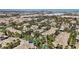 Wide aerial view of a community with tile roofs, palm trees, tennis court, and lush landscaping at 7119 S Durango Dr # 211, Las Vegas, NV 89113