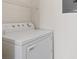 Bright laundry room with a white dryer and wire shelving for optimal organization at 7119 S Durango Dr # 211, Las Vegas, NV 89113