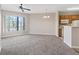 Bright living room featuring carpeting and a ceiling fan, open to the kitchen at 7119 S Durango Dr # 211, Las Vegas, NV 89113