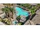 An aerial view of a sparkling community pool with lounge chairs and palm trees at 7119 S Durango Dr # 211, Las Vegas, NV 89113