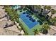 Aerial shot highlighting the community tennis court amidst palm trees and lush landscaping at 7119 S Durango Dr # 211, Las Vegas, NV 89113