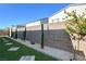 Landscaped backyard featuring turf, decorative rock, and several trees along a block wall for privacy at 7208 Grace Estate Ave, Las Vegas, NV 89113