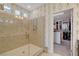Modern bathroom featuring a glass shower with neutral tile and a glimpse into an organized walk-in closet at 7208 Grace Estate Ave, Las Vegas, NV 89113