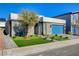 Modern home exterior with a well-maintained lawn, tidy landscaping, and a blue garage door at 7208 Grace Estate Ave, Las Vegas, NV 89113