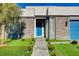 Modern home with stone facade, blue front door, desert landscaping and a blue garage door at 7208 Grace Estate Ave, Las Vegas, NV 89113