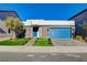 Street view of single-story home with stone facade, desert landscaping, blue garage door and blue front door at 7208 Grace Estate Ave, Las Vegas, NV 89113