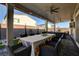Inviting covered patio with dining and seating, a ceiling fan, and a lush backyard providing a relaxing retreat at 7208 Grace Estate Ave, Las Vegas, NV 89113