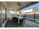 Covered patio with ceiling fans, dining table and chairs, overlooking a landscaped backyard with privacy wall at 7208 Grace Estate Ave, Las Vegas, NV 89113