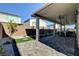 Wide angle shot of covered patio with multiple seating areas and landscaping in the backyard at 7208 Grace Estate Ave, Las Vegas, NV 89113