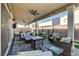 Large covered patio with multiple seating areas, including a dining table and comfortable lounge furniture at 7208 Grace Estate Ave, Las Vegas, NV 89113