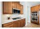 Modern kitchen featuring stainless steel appliances, white backsplash, and wood finish cabinets at 7466 Matilda St, Las Vegas, NV 89113