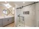 Sleek bathroom boasts a glass enclosed shower, and gray double sink vanity with modern round mirrors at 7477 Ullom Dr, Las Vegas, NV 89139