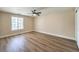 Bedroom with a ceiling fan, neutral walls, and wood-look floors, offering a serene and comfortable space at 7477 Ullom Dr, Las Vegas, NV 89139