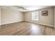A bright bedroom with a ceiling fan, window with blinds, and wood-look flooring at 7477 Ullom Dr, Las Vegas, NV 89139