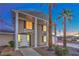 Charming two-story home with a grand entrance, stately columns, and manicured landscaping at night at 7477 Ullom Dr, Las Vegas, NV 89139