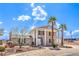 Two-story home featuring a welcoming front porch supported by columns and complemented by palm trees at 7477 Ullom Dr, Las Vegas, NV 89139