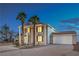 Elegant two-story home showcasing stately pillars, well-maintained landscaping, and a spacious driveway in twilight at 7477 Ullom Dr, Las Vegas, NV 89139