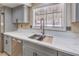 Close up shot of the stainless sink and grey cabinetry found in the updated kitchen at 7477 Ullom Dr, Las Vegas, NV 89139