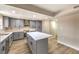 A modern kitchen features gray cabinets, stainless steel appliances, and a large island with a marble countertop at 7477 Ullom Dr, Las Vegas, NV 89139