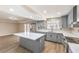 Kitchen featuring grey cabinetry, stainless appliances, quartz countertops, and an island at 7477 Ullom Dr, Las Vegas, NV 89139