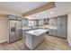 Updated kitchen features gray cabinets, stainless steel appliances, marble countertops, and an island with breakfast bar at 7477 Ullom Dr, Las Vegas, NV 89139