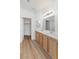 Bathroom featuring double sinks, white countertops, wood cabinets, and a walk-in closet access at 7936 Pinnochio Ave, Las Vegas, NV 89131