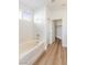 Bright bathroom with a tub and shower combination, complemented by modern fixtures and wood-style flooring at 7936 Pinnochio Ave, Las Vegas, NV 89131