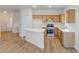 Open kitchen layout featuring an island, wooden cabinets, stainless steel appliances, and modern countertops at 7936 Pinnochio Ave, Las Vegas, NV 89131