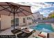 Backyard featuring a private pool, lounge chairs, and an umbrella for relaxation at 7936 Pinnochio Ave, Las Vegas, NV 89131