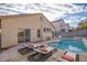 A backyard pool features lounge seating, an umbrella, and a view of the home's exterior at 7936 Pinnochio Ave, Las Vegas, NV 89131