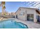 Backyard pool with tanning ledge, privacy wall, and views of the home's exterior at 7936 Pinnochio Ave, Las Vegas, NV 89131