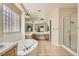 Bathroom featuring a soaking tub, glass block window, vanity, and a glass-enclosed shower at 8305 Chapelle Ct, Las Vegas, NV 89131
