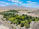 Scenic aerial view with mature trees, open lawns and a backdrop of distant mountains and blue skies at 8504 Mystic Night Ave, Las Vegas, NV 89143