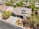 Expansive aerial view of a single-story brick home with a three-car garage, mature trees, and manicured landscaping at 8504 Mystic Night Ave, Las Vegas, NV 89143