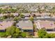 Community aerial view features a backyard with a covered patio, green grass, mature trees, desert landscaping, and a pool at 8504 Mystic Night Ave, Las Vegas, NV 89143