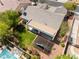 Backyard aerial view includes a covered patio, lush grass, desert landscaping, and a sparkling pool at 8504 Mystic Night Ave, Las Vegas, NV 89143