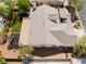 Aerial view of backyard includes a covered patio, a play set, mature trees, and lush green grass at 8504 Mystic Night Ave, Las Vegas, NV 89143