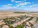 An aerial shot of a desert community nestled near a lake and mountains under a sunny sky at 8504 Mystic Night Ave, Las Vegas, NV 89143