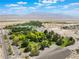 Aerial shot shows a lush park and lake with the desert and mountains in the background at 8504 Mystic Night Ave, Las Vegas, NV 89143