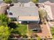 Backyard aerial view includes a covered patio, lush grass, a play set and desert landscaping at 8504 Mystic Night Ave, Las Vegas, NV 89143