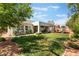 Expansive backyard with lush lawn, covered patio, mature trees, and a playset at 8504 Mystic Night Ave, Las Vegas, NV 89143