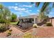 Spacious backyard featuring a playset, rock landscaping, trees, and a glimpse of the home at 8504 Mystic Night Ave, Las Vegas, NV 89143