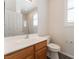 Bathroom with wood cabinet, white sink, toilet and window with shutters at 8504 Mystic Night Ave, Las Vegas, NV 89143