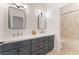 Stylish bathroom with a dual sink vanity, modern lighting, and a tiled shower/tub combo at 8504 Mystic Night Ave, Las Vegas, NV 89143