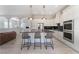 Bright kitchen featuring white cabinets, a center island with seating, stainless steel appliances, and modern pendant lighting at 8504 Mystic Night Ave, Las Vegas, NV 89143