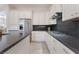 Close up of a bright kitchen with a stainless steel refrigerator and gas cooktop with white cabinets at 8504 Mystic Night Ave, Las Vegas, NV 89143
